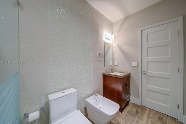 bathroom featuring vanity, toilet, wood-type flooring, and a bidet