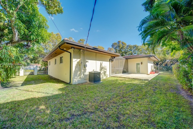 back of house featuring a yard, a patio area, and central air condition unit