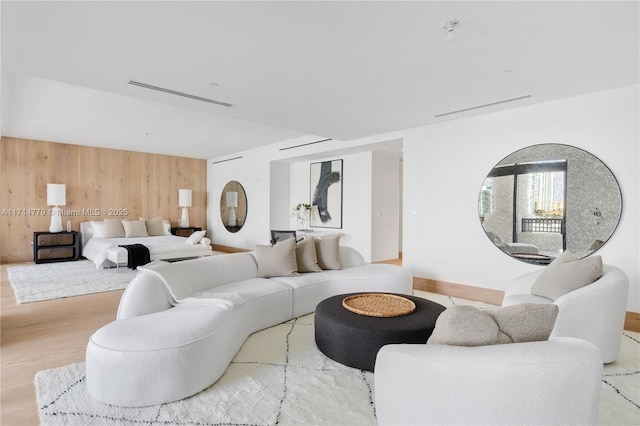 bedroom featuring wood walls, visible vents, and wood finished floors