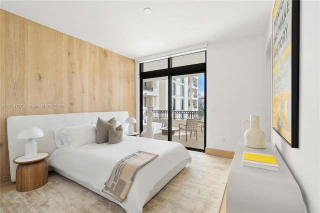 bedroom featuring access to exterior, baseboards, and a wall of windows