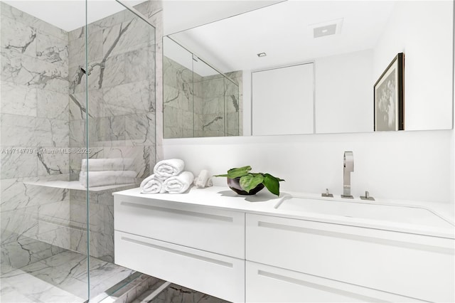 full bath with visible vents, vanity, and a marble finish shower