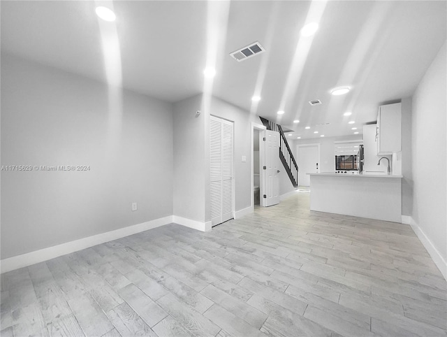 unfurnished room featuring light wood-type flooring and sink