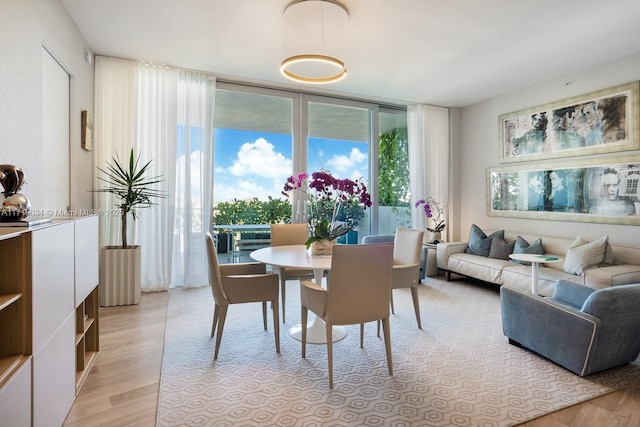 dining room with floor to ceiling windows and light hardwood / wood-style flooring