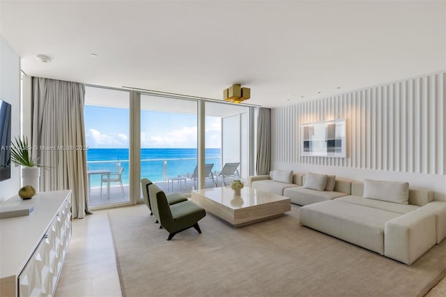 living room featuring floor to ceiling windows, a wealth of natural light, and a water view