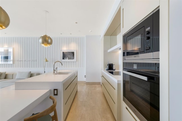 kitchen with pendant lighting, black electric stovetop, sink, built in microwave, and wall oven