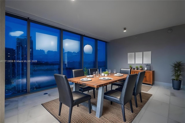 dining area with light tile patterned floors and a wall of windows