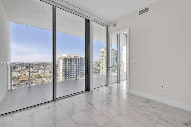 interior space with tile patterned flooring, a wall of windows, and a wealth of natural light