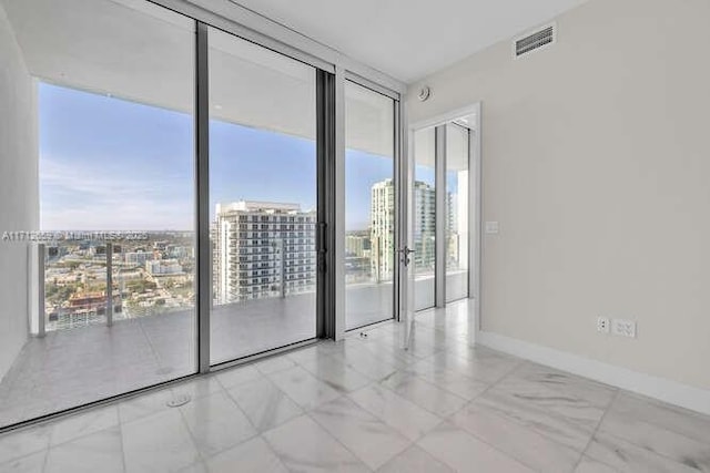 empty room featuring expansive windows and a healthy amount of sunlight