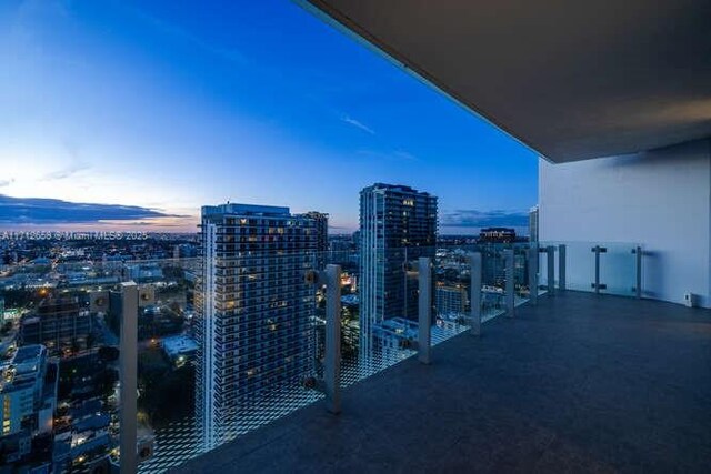 unfurnished living room with a wealth of natural light, a water view, light tile patterned floors, and a wall of windows