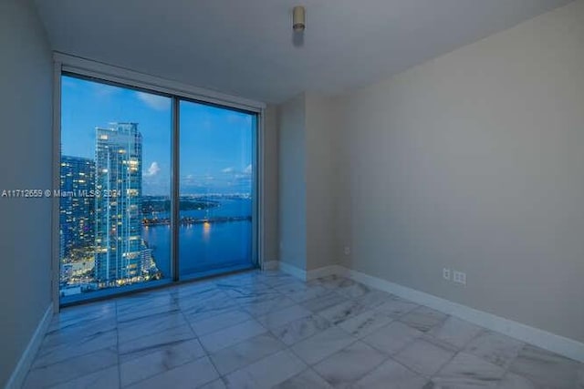 empty room featuring a water view and expansive windows