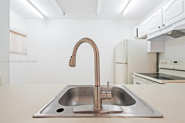 kitchen with extractor fan, white appliances, white cabinetry, and sink