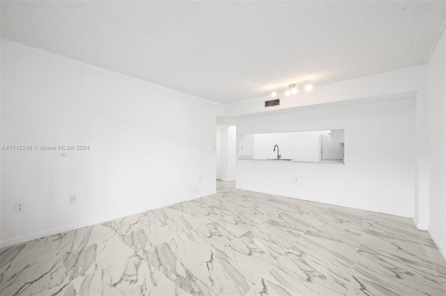 empty room featuring sink and a textured ceiling