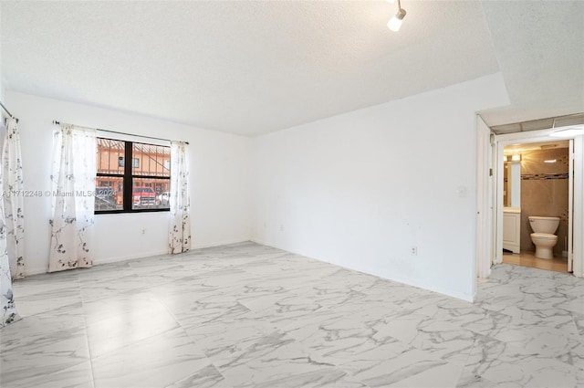 unfurnished room featuring a textured ceiling