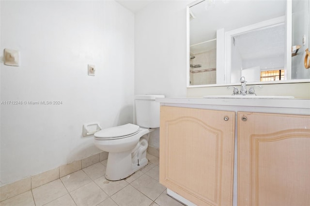 bathroom featuring tile patterned floors, vanity, toilet, and a shower