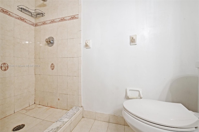 bathroom with tiled shower, tile patterned flooring, and toilet