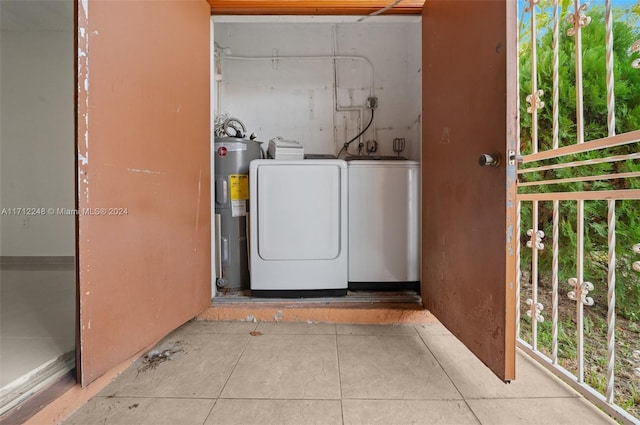 laundry area featuring electric water heater, washer and clothes dryer, and light tile patterned floors