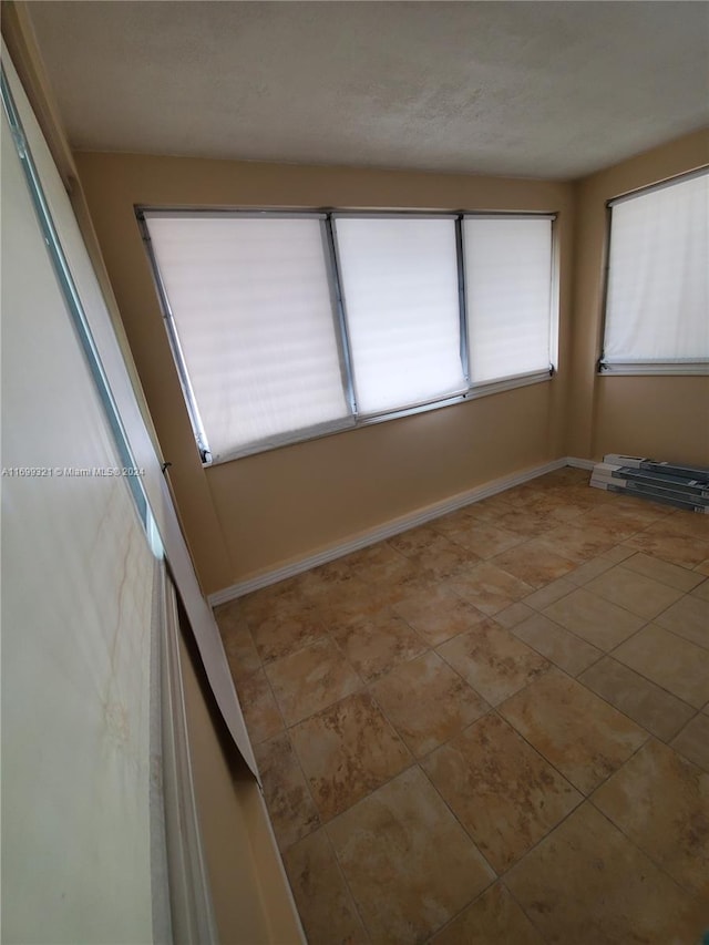 empty room featuring light tile patterned floors and a wealth of natural light