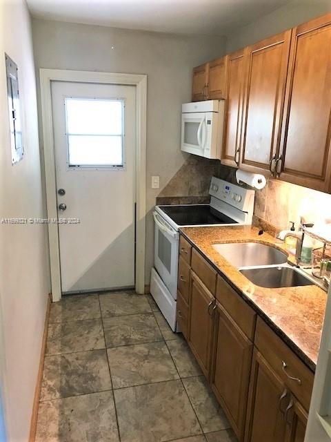 kitchen with white appliances, sink, and tasteful backsplash