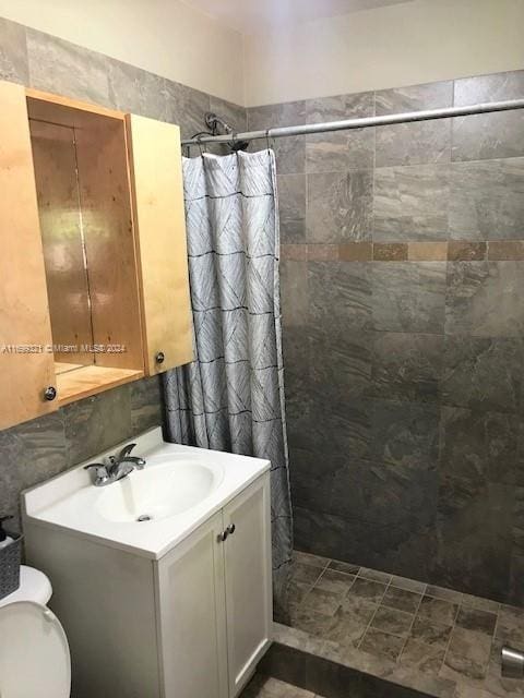 bathroom with toilet, vanity, and walk in shower