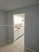 kitchen featuring light tile patterned floors and white cabinetry