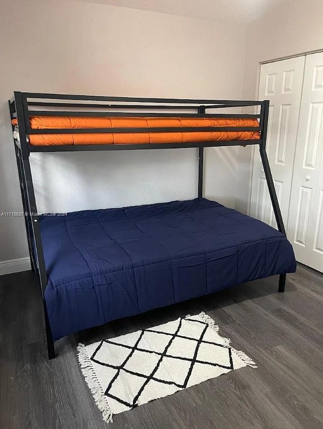 unfurnished bedroom with a closet and dark wood-type flooring