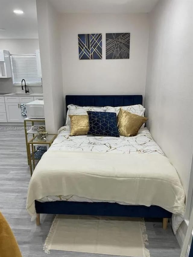 bedroom featuring sink and light hardwood / wood-style flooring