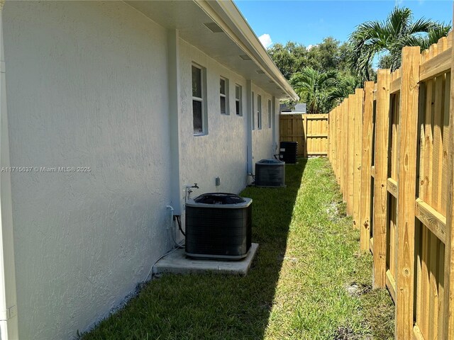 view of home's exterior with a lawn and central AC unit