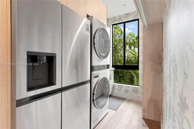 washroom featuring stacked washer and dryer and light wood-type flooring