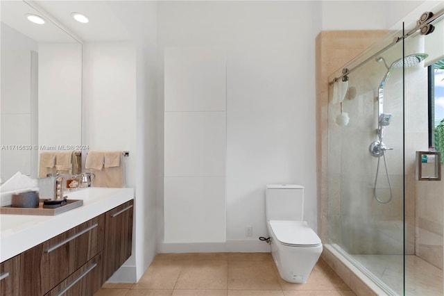 bathroom with tile patterned flooring, vanity, toilet, and a shower with shower door