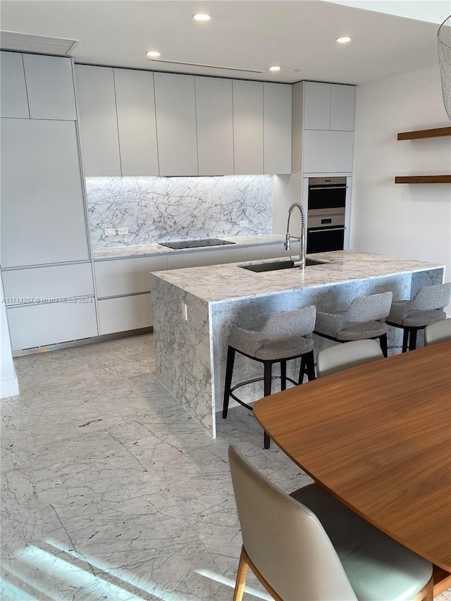 kitchen with white cabinetry, black electric cooktop, sink, and double oven