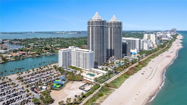 birds eye view of property with a water view and a beach view