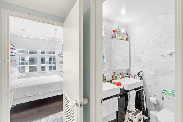 bathroom with vanity, toilet, and tile walls