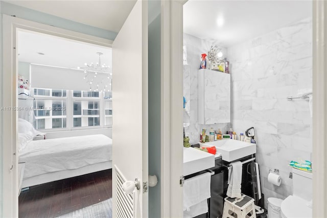 bathroom featuring tile walls, hardwood / wood-style floors, vanity, and toilet