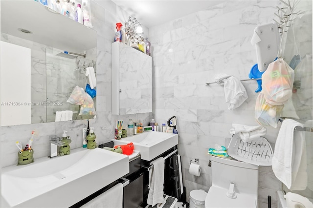 bathroom featuring a shower with door, vanity, backsplash, tile walls, and toilet