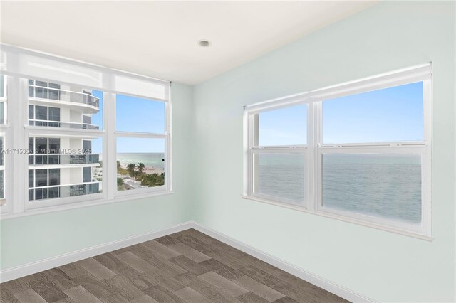 interior space with a crib, a water view, and dark hardwood / wood-style floors