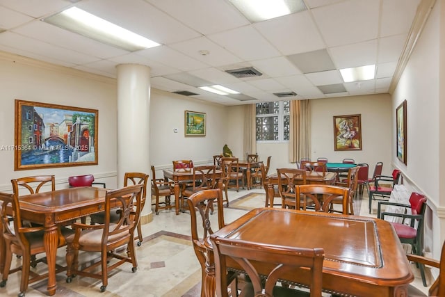 tiled dining space featuring a drop ceiling