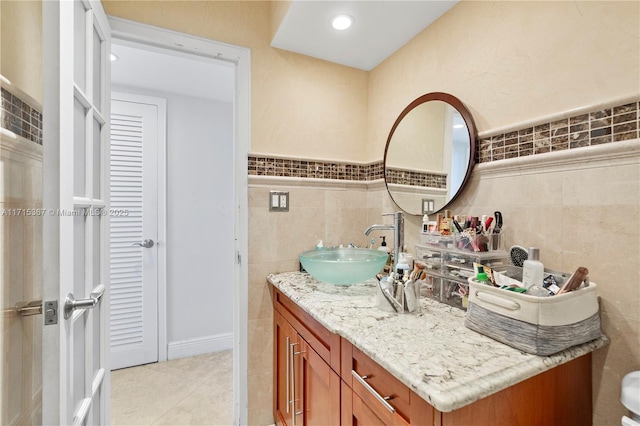 bathroom with tile patterned floors, vanity, and tile walls