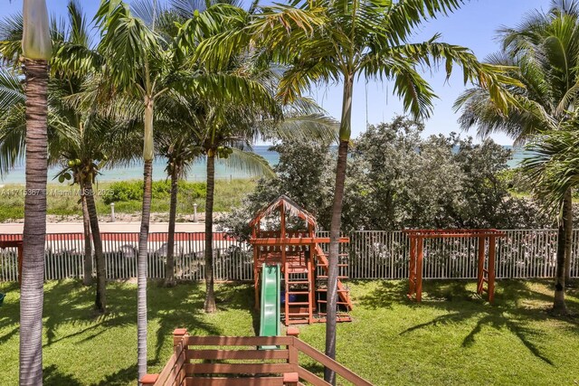 view of play area featuring a water view and a lawn