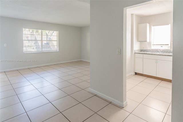 unfurnished room with sink and light tile patterned floors