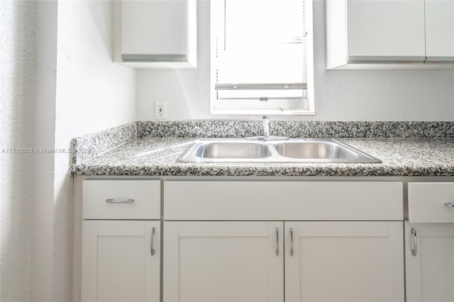 kitchen featuring white cabinetry and sink