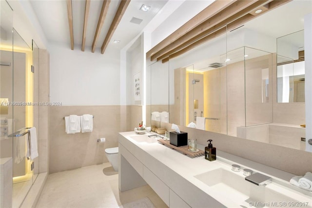 bathroom with vanity, a shower with door, toilet, tile walls, and beamed ceiling