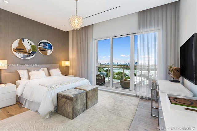 bedroom featuring wood-type flooring and an inviting chandelier