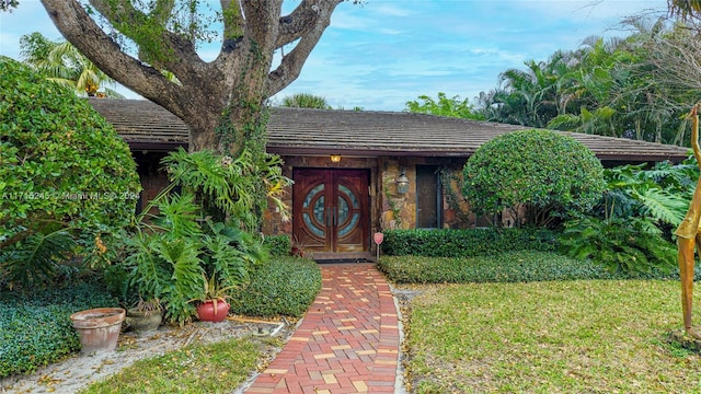 property entrance with a lawn