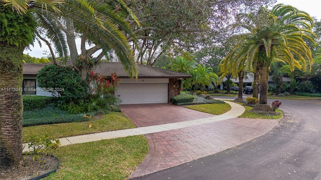 3111 N 52nd Ave, Hollywood, FL 33021 - obstructed view of property with decorative driveway, a garage, and a tile roof