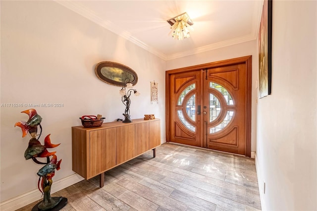 entryway with light hardwood / wood-style floors, ornamental molding, and french doors