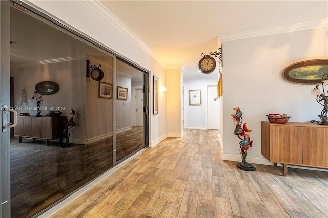 corridor with ornamental molding and light hardwood / wood-style flooring