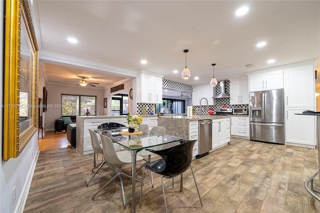 3111 N 52nd Ave, Hollywood, FL 33021 - kitchen featuring appliances with stainless steel finishes, ornamental molding, light wood-style floors, decorative backsplash, and a peninsula