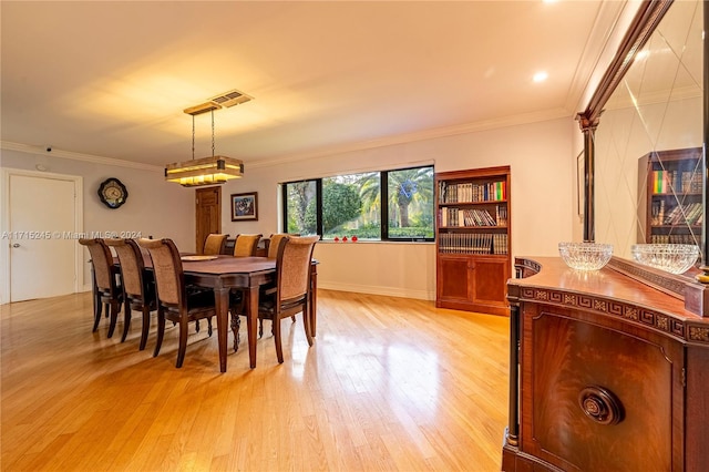 dining room featuring light hardwood / wood-style flooring and crown molding