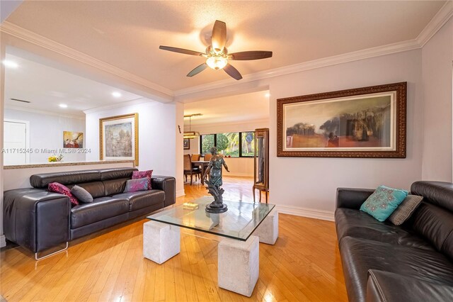 living room with ceiling fan, light hardwood / wood-style floors, and ornamental molding