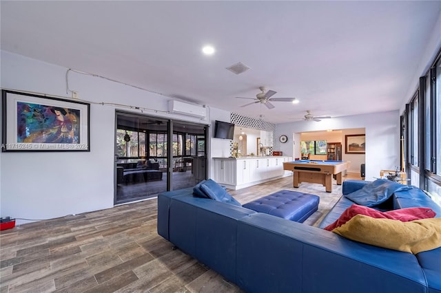 living room featuring a wall unit AC, ceiling fan, hardwood / wood-style floors, and billiards